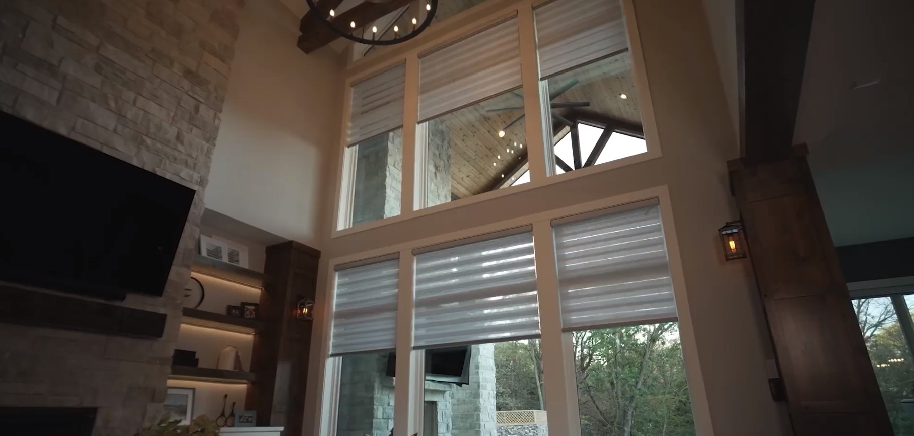 living room with large windows using motorization to bring down banded shades